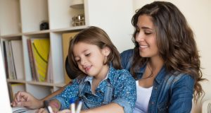 alt="Young woman with little girl using computer at home, self isolating"