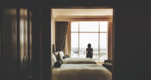 woman standing near window inside bedroom