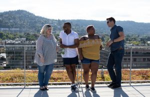 four people leaning on railings