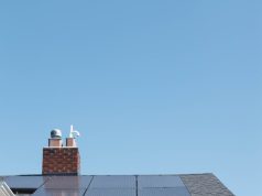 brown brick house with solar panels on roof