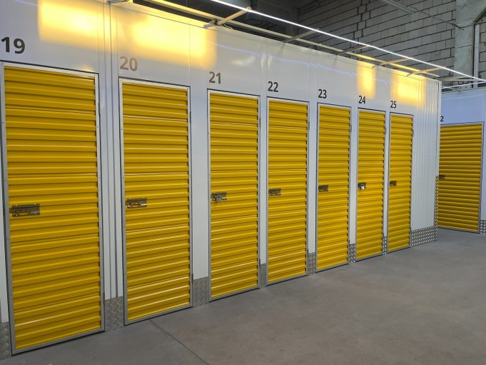 a row of storage units with yellow doors