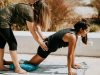 woman in black tank top and black shorts kneeling on mat