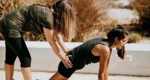 woman in black tank top and black shorts kneeling on mat
