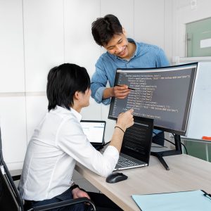 Engineers reviewing code on a monitor: Considerations Product Teams Ought to Evaluate Prior to Integrating a Public-Record API