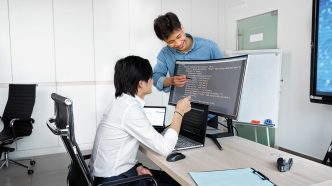 Engineers reviewing code on a monitor: Considerations Product Teams Ought to Evaluate Prior to Integrating a Public-Record API