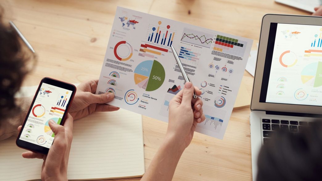 Proven Category Knowledge Is What Divides Great Agencies From Merely Adequate Ones: marketing specialists reviewing SEO and campaign analytics charts at a desk