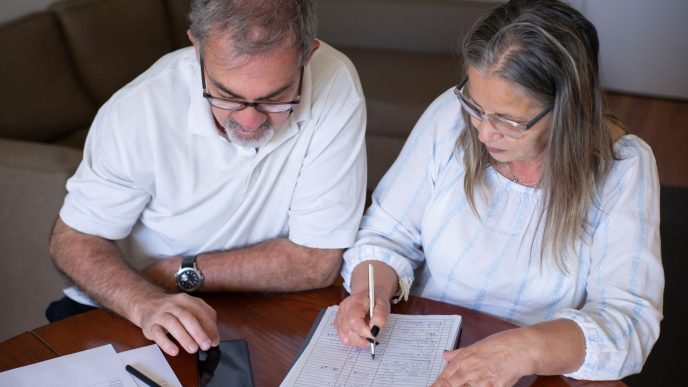 The cost of withdrawing pension cash early can appear years later: an older couple going through pension and retirement paperwork together at home